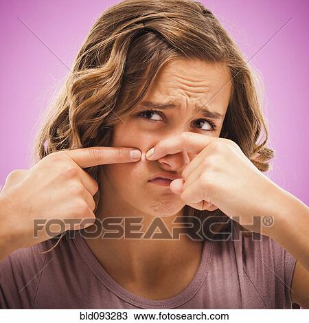 Stock Image - Caucasian teenager popping pimple. Fotosearch