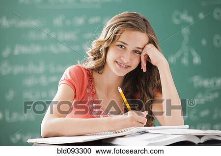 Stock Image - Caucasian teenager studying in classroom. Fotosearch