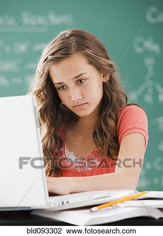 Caucasian teenager using laptop in classroom View Large Photo Image Stock Image - Caucasian teenager using laptop in classroom. Fotosearch