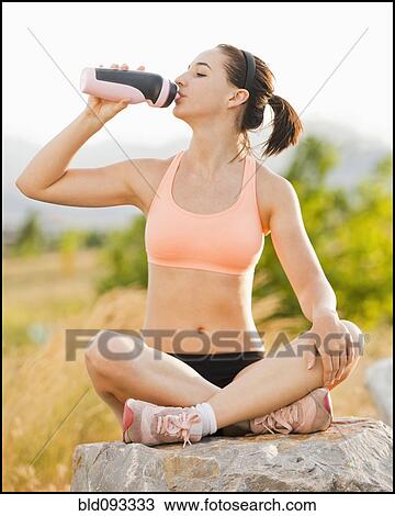 Caucasian woman drinking water after workout View Large Photo Image Stock Image - Caucasian woman drinking water after workout. Fotosearch