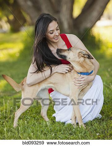 Stock Photo - Caucasian woman hugging dog. Fotosearch