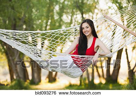 Stock Photograph - Caucasian woman laying in hammock. Fotosearch