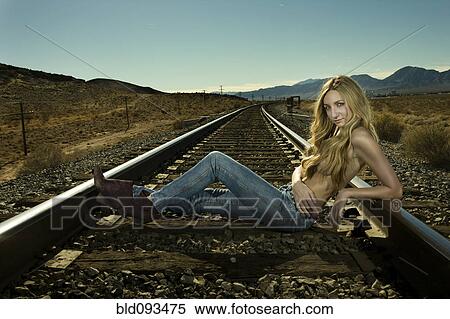 Stock Photography - Caucasian woman laying on railroad tracks. Fotosearch