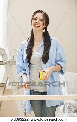 Caucasian woman measuring wood View Large Photo Image Stock Image - Caucasian woman measuring wood. Fotosearch