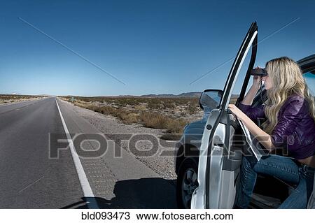 Caucasian woman parked on roadside using binoculars View Large Photo Image Stock Image - Caucasian woman parked on roadside using binoculars. Fotosearch