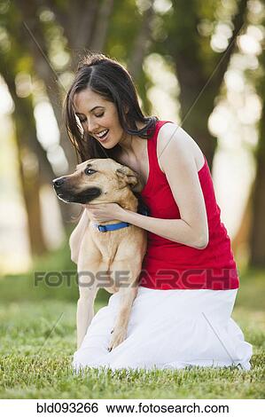 Stock Photograph - Caucasian woman petting dog. Fotosearch