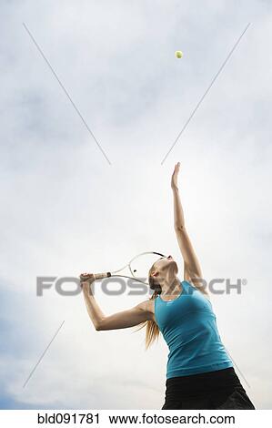 Stock Image - Caucasian woman playing tennis. Fotosearch