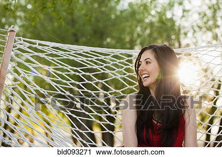 Stock Image - Caucasian woman sitting in hammock. Fotosearch
