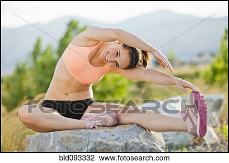 Stock Image - Caucasian woman stretching before workout. Fotosearch