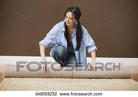 Caucasian woman unrolling carpet View Large Photo Image Stock Image - Caucasian woman unrolling carpet. Fotosearch