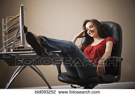 Caucasian woman with feet up on home office desk View Large Photo Image Stock Image - Caucasian woman with feet up on home office desk. Fotosearch