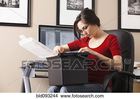 Picture - Caucasian woman working at desk in home office. Fotosearch