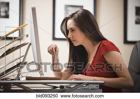 Caucasian woman working at desk in home office View Large Photo Image Stock Image - Caucasian woman working at desk in home office. Fotosearch