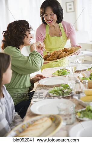 Stock Image - Family eating dinner together. Fotosearch