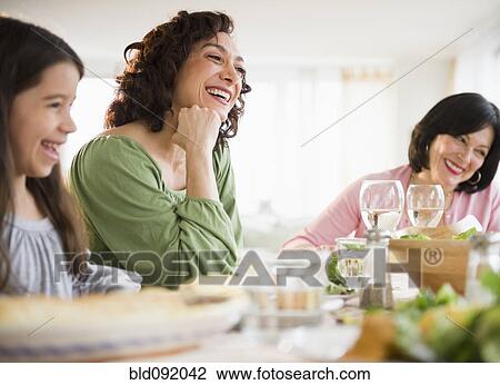 Stock Image - Family eating dinner together. Fotosearch