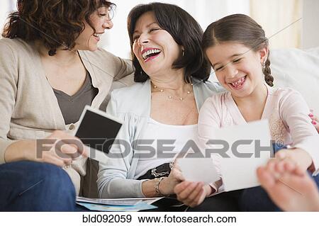 Stock Photo - Family looking at photographs together. Fotosearch