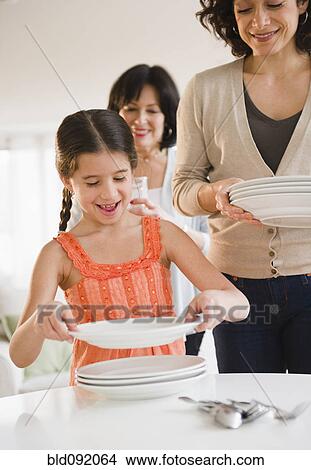 Picture - Family setting the table together. Fotosearch