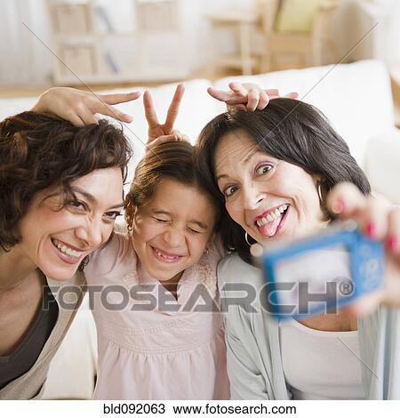 Stock Image - Family taking self-portrait with digital camera. Fotosearch