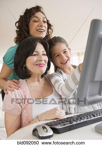 Stock Image - Family using computer together. Fotosearch