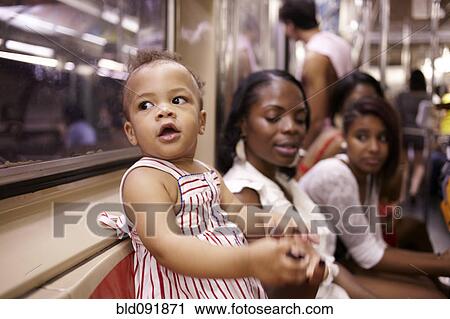 Stock Image - Family watching curious mixed race girl. Fotosearch