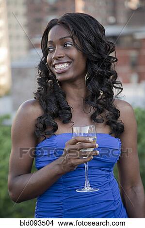 Glamorous African American woman drinking wine outdoors View Large Photo Image Picture - Glamorous African American woman drinking wine outdoors. Fotosearch