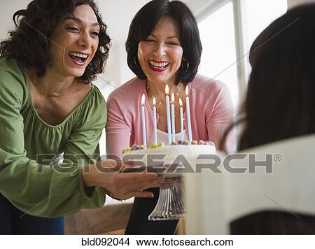 Picture - Grandmother and mother giving birthday cake to daughter. Fotosearch