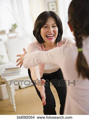 Picture - Grandmother hugging granddaughter. Fotosearch