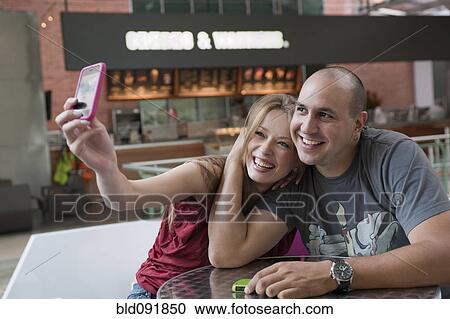 Hispanic couple taking self-portrait with cell phone View Large Photo Image Stock Image - Hispanic couple taking self-portrait with cell phone. Fotosearch