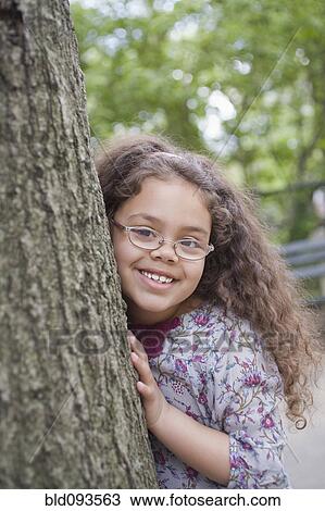 Hispanic girl leaning on tree trunk View Large Photo Image Stock Image - Hispanic girl leaning on tree trunk. Fotosearch