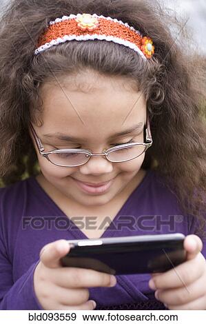 Hispanic girl text messaging on cell phone View Large Photo Image Stock Photo - Hispanic girl text messaging on cell phone. Fotosearch