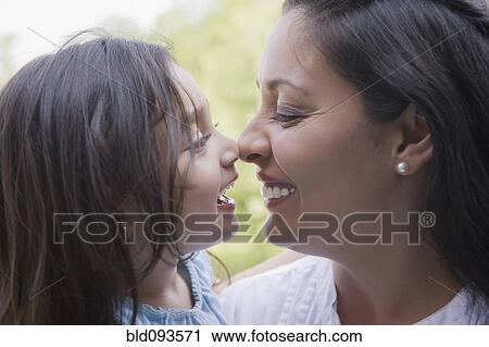 Stock Image - Hispanic mother rubbing noses with daughter. Fotosearch