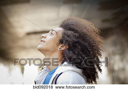 Mixed race teenager looking up outdoors View Large Photo Image Stock Photo - Mixed race teenager looking up outdoors. Fotosearch