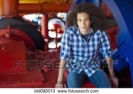 Mixed race teenager sitting on machinery View Large Photo Image Stock Image - Mixed race teenager sitting on machinery. Fotosearch