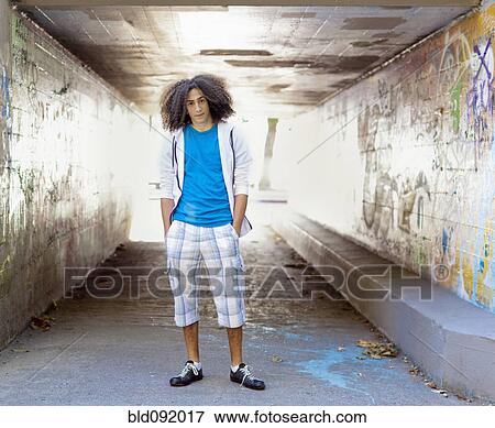 Stock Photo - Mixed race teenager standing in urban underpass. Fotosearch