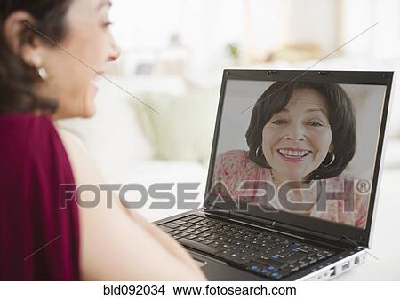 Mother and daughter talking over video chat View Large Photo Image Picture - Mother and daughter talking over video chat. Fotosearch