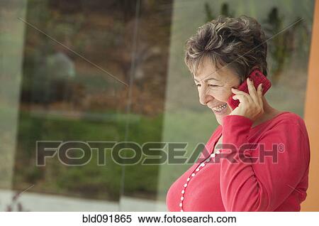 Stock Photography - Senior Hispanic woman talking on cell phone. Fotosearch