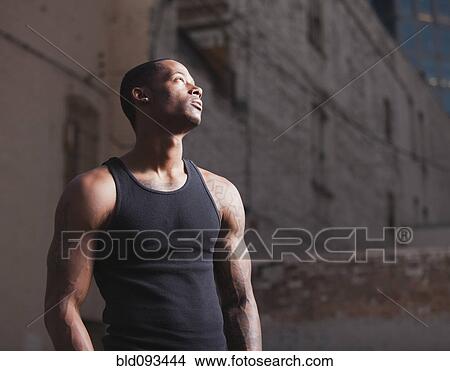 Picture - Serious Black man standing outdoors. Fotosearch