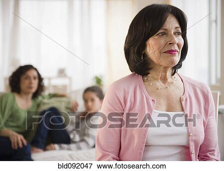 Stock Photo - Serious woman with family in background. Fotosearch