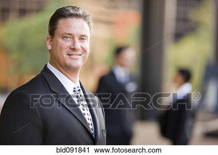 Smiling Caucasian businessman standing outdoors View Large Photo Image Stock Image - Smiling Caucasian businessman standing outdoors. Fotosearch