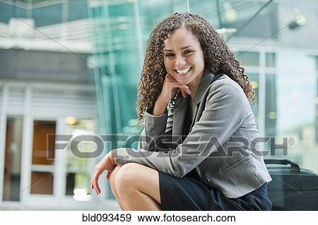 Smiling Caucasian businesswoman sitting outdoors View Large Photo Image Stock Photo - Smiling Caucasian businesswoman sitting outdoors. Fotosearch