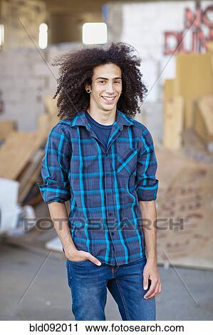 Stock Image - Smiling mixed race teenager with hands in pockets. Fotosearch