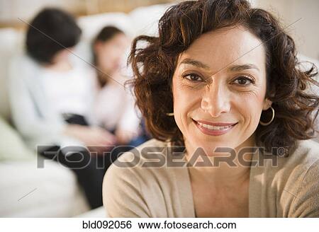 Stock Photograph - Smiling woman with family in background. Fotosearch