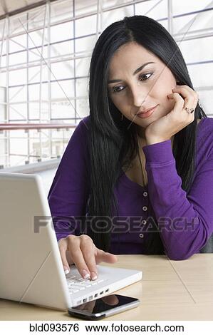 Stock Photograph - Turkish businesswoman typing on laptop. Fotosearch