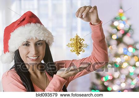 Stock Photo - Turkish woman holding up Christmas ornament. Fotosearch
