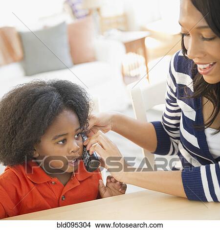 Picture - African American mother and son using telephone. Fotosearch