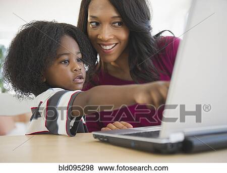 African American mother and son using laptop together View Large Photo Image Stock Photo - African American mother and son using laptop together. Fotosearch