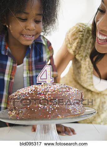 Stock Photo - African American mother and son with birthday cake. Fotosearch