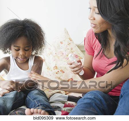 African American mother putting lotion on son View Large Photo Image Stock Photo - African American mother putting lotion on son. Fotosearch