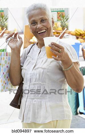 Stock Photo - African American woman drinking juice. Fotosearch