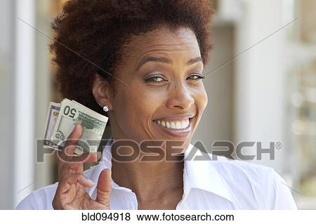 Stock Photo - African American woman holding 50 dollar bill. Fotosearch